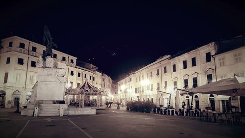 Street amidst buildings in city at night