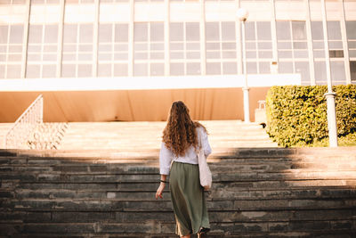 Rear view of woman standing on staircase