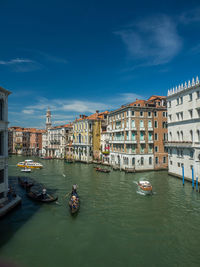 Boats in canal amidst buildings in city