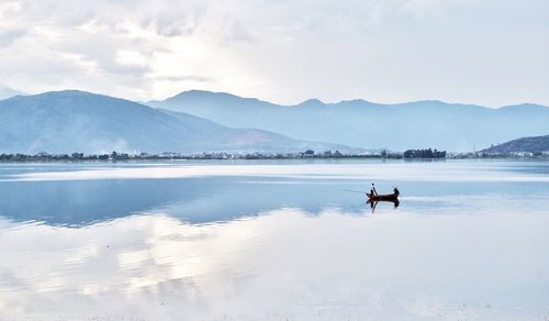 Man in lake against mountain range