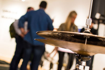 Close-up of cymbals with people in background