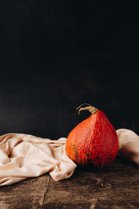 Close-up of pumpkin on table against black background
