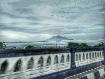 Bridge over road against sky during rainy season