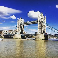 Bridge over river against cloudy sky