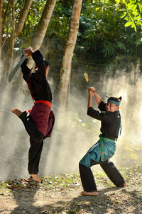 Full length of men sitting on tree