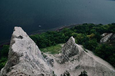 High angle view of rocks by sea against mountain