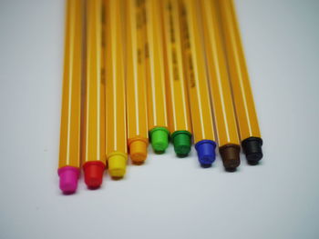 Close-up of multi colored pencils over white background