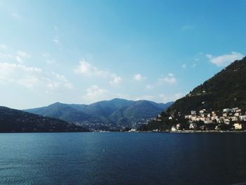 Scenic view of sea by mountains against sky