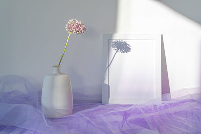 Close-up of white flower vase on table against wall