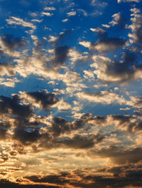 Low angle view of sunlight streaming through clouds