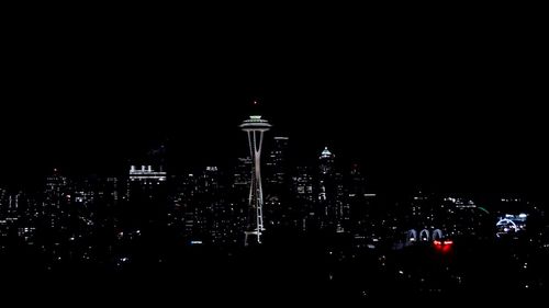 Illuminated cityscape against sky at night