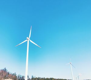 Low angle view of windmill against clear blue sky