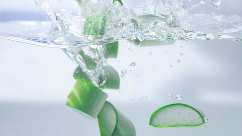 Close-up of water drops on glass over white background