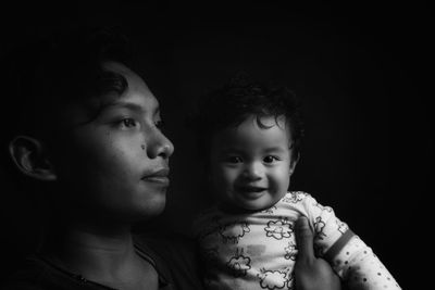 Close up monochrome baby girl is being carried by her brother