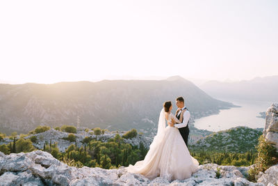 Couple kissing on mountain against mountains