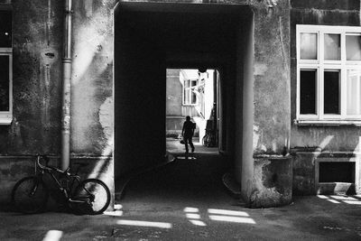 Rear view of man standing against building in city