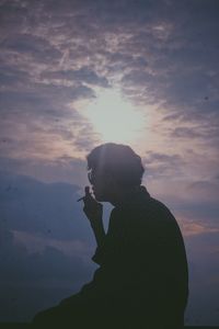Side view of silhouette man standing against sky during sunset