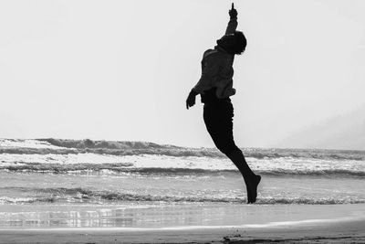 Full length of man on beach against clear sky