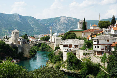 View of town by river against sky