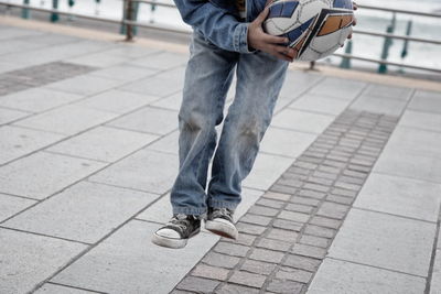 Low section of man standing on sidewalk