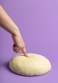 Close-up of hand holding ice cream over white background