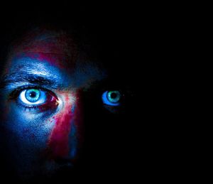 Close-up portrait of a serious young man in the dark