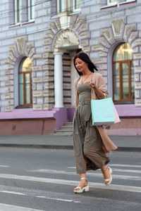 Young beautiful woman smiling going to the shops in the city