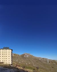 Low angle view of buildings against clear blue sky