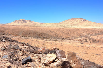 Scenic view of desert against clear blue sky