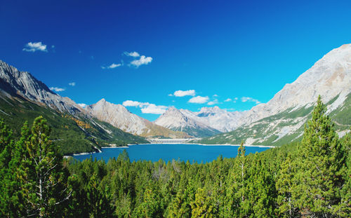 Scenic view of lake and mountains against blue sky