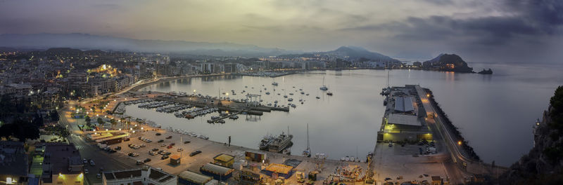 High angle view of illuminated buildings against cloudy sky