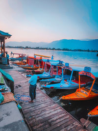 Boats moored on beach against sky during sunset