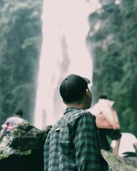 Rear view of man looking at waterfall