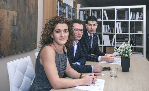 Portrait of business people sitting at desk in office