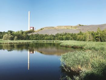 Scenic view of lake against clear blue sky