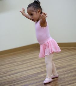 Girl with arms outstretched standing in dance studio