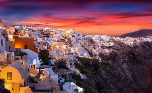 Houses in town against sky during sunset