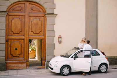 Rear view of woman standing by door of building