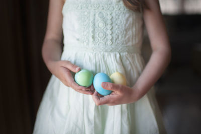 Midsection of girl holding easter eggs at home
