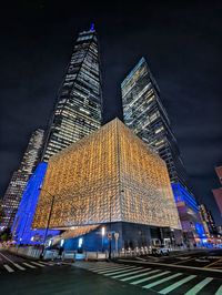 Low angle view of illuminated buildings in city at night