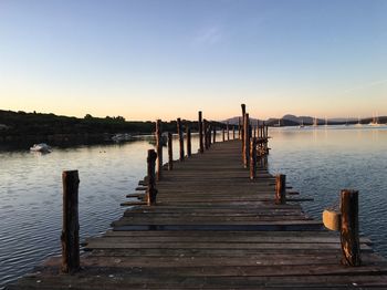 Wooden pier over lake against clear sky