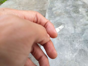 Midsection of person holding cigarette