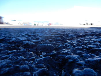 Surface level of stones on beach against sky