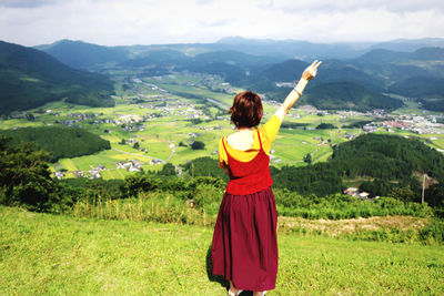 Rear view of woman standing against landscape