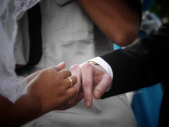 Midsection of bride and groom during wedding ceremony