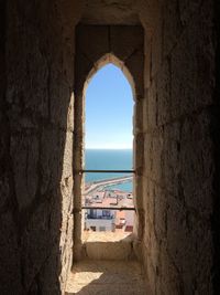 Scenic view of sea against clear sky seen through arch window