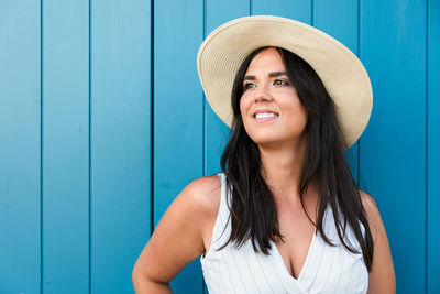 Portrait of a smiling young woman in front of blue door.