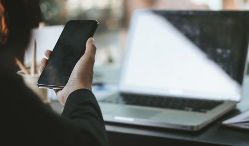 Midsection of man using mobile phone