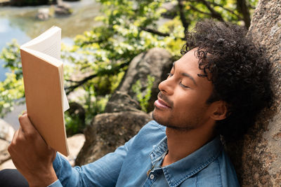 Side view of young man using mobile phone