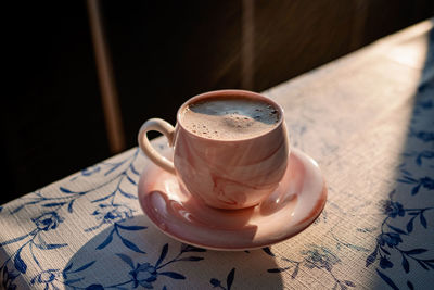 Turkish coffee in a pink cup with a saucer in the sun close-up. coffee break. high quality photo